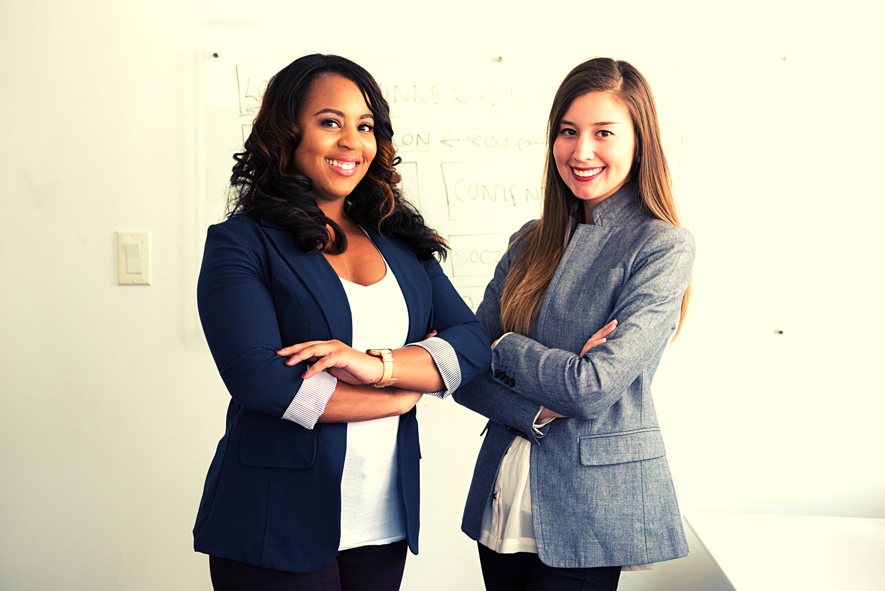 Two Smiling Women in Gray and Black Coat